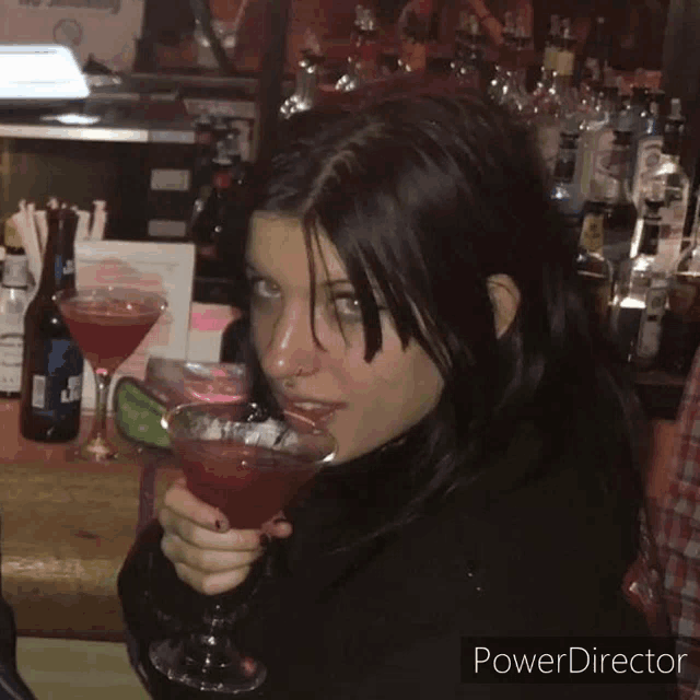 a woman holding a martini in front of a bar that says power director on it