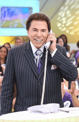 a man in a suit is talking on a telephone with a name tag that says iris