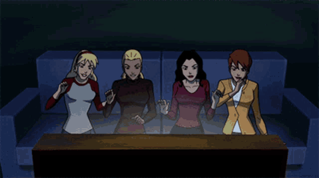 a group of women are sitting on a couch with their hands in the air