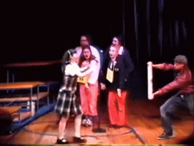 a group of people on a stage with one wearing a yellow shirt that says ' a ' on it