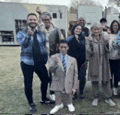 a group of people standing next to each other in a field .