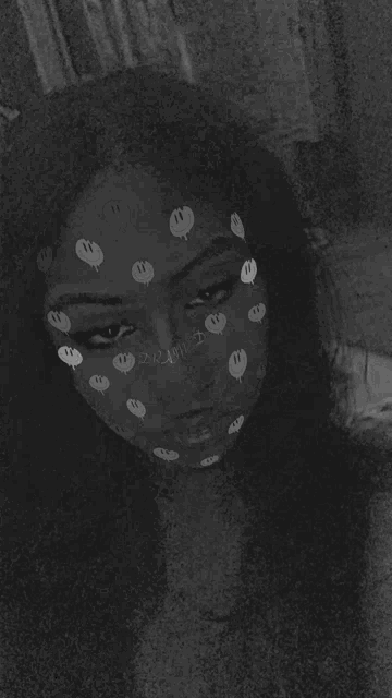 a black and white photo of a woman with stickers on her face .