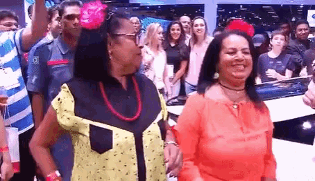two women are standing next to each other in a crowd .