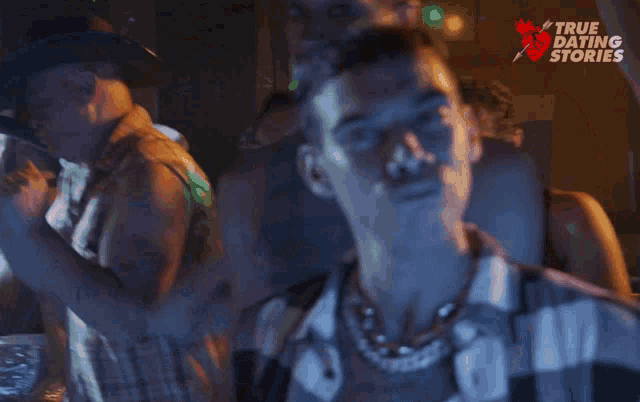 a man in a plaid shirt stands in a crowd of people with a true dating story logo on the bottom