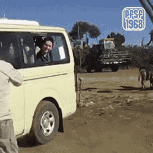 a yellow van is parked on a dirt road and the year 1968 is on the bottom