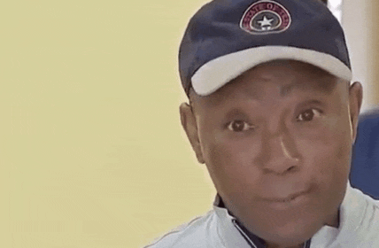 a man wearing a baseball cap and a white jacket is looking at the camera .
