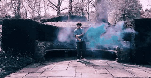 a man is standing in front of a bench surrounded by blue smoke