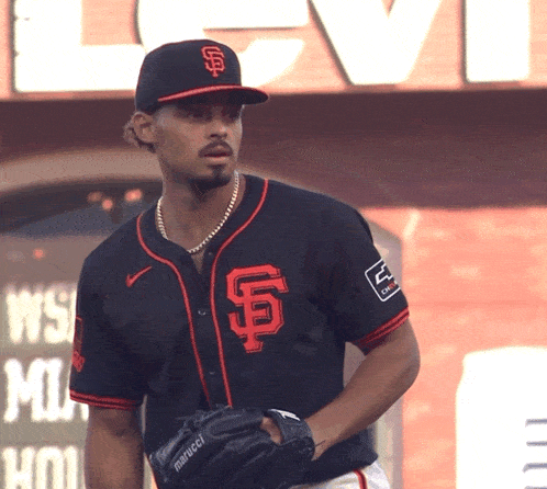 a man wearing a san francisco giants jersey and a marucci glove