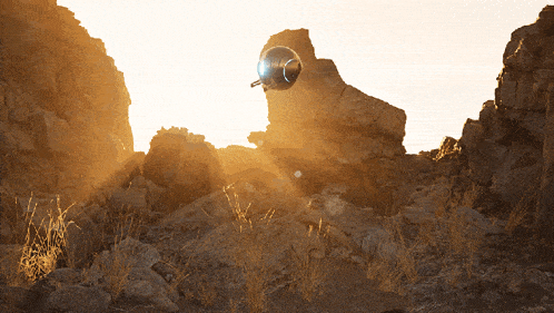 the sun shines brightly through the rocks and grass