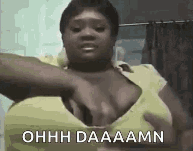 a woman is taking off her shirt in a bathroom and making a funny face .