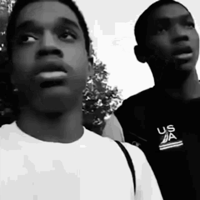 two men are standing next to each other with one wearing a shirt that says " us da "