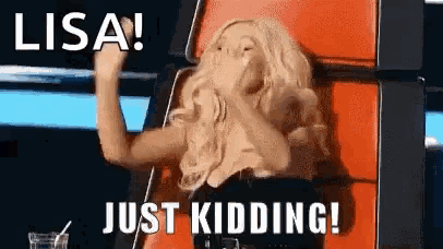 a woman is sitting in a chair with her hand in her mouth and the words `` lisa just kidding ! ''