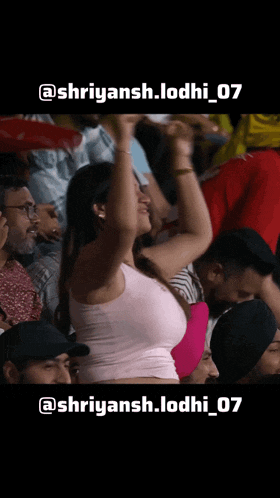 a woman in a pink tank top stands in a crowd of people with the hashtag shriyansh.lodhi_07 on the bottom