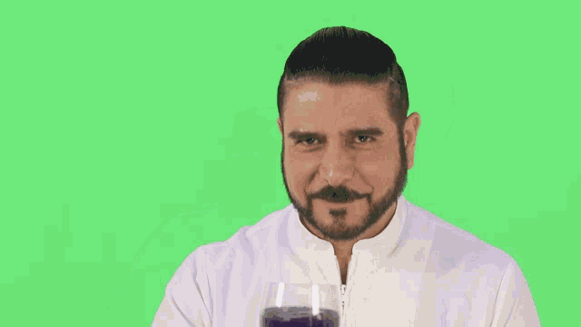 a man is holding a glass of purple wine