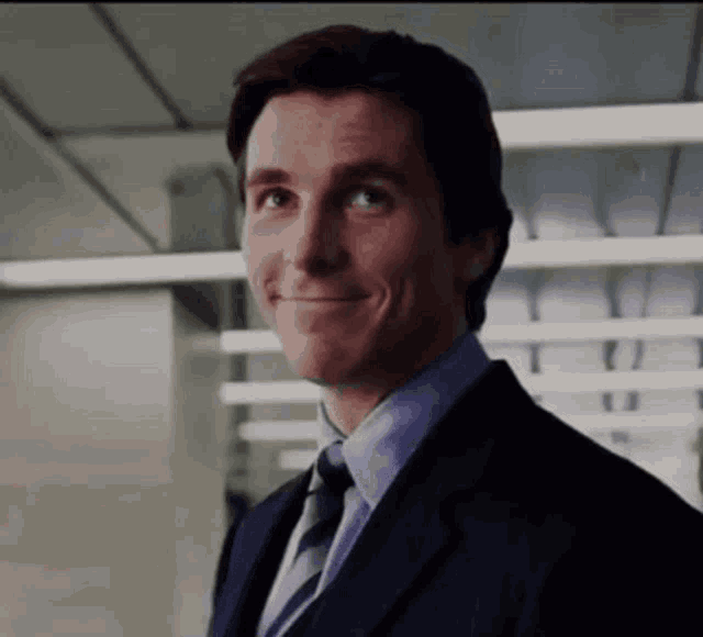 a man wearing a suit and tie is smiling
