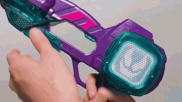 a person is holding a purple and blue toy