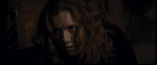 a dark room with a painting of a man and woman