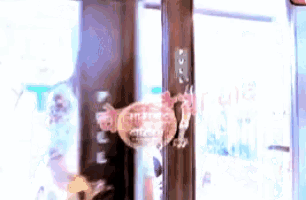 a blurred image of a person holding a lollipop in front of a sign that says ' coca cola '