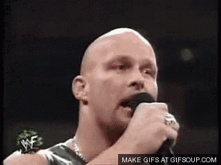 a bald man is singing into a microphone with a mustache .