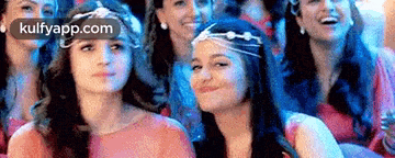 a group of women are sitting in a row and smiling .