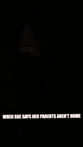 a man in a white shirt and grey shorts is standing in a hallway with the caption when she says her parents aren
