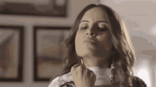 a woman is making a funny face while holding her fist to her chin .
