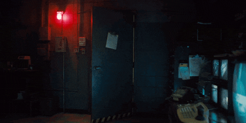 a man holding a bag in a dark room with a sign that says exit on it