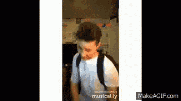 a young man wearing a backpack is standing in front of a makeagif.com screen