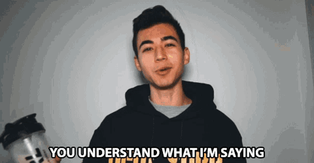 a man in a black hoodie is holding a shaker and says you understand what i 'm saying