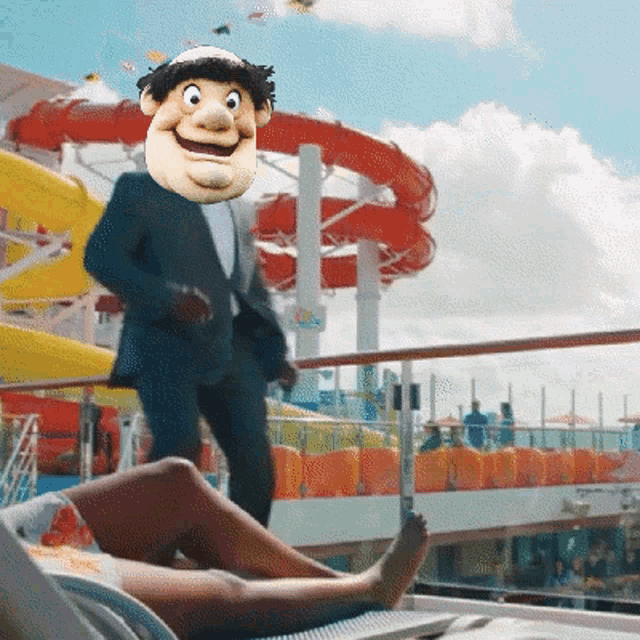 a man in a suit is standing in front of a water slide with a mask on his head