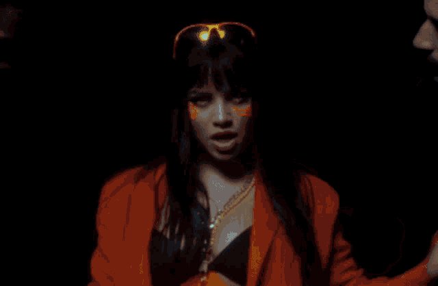 a woman wearing sunglasses and an orange jacket