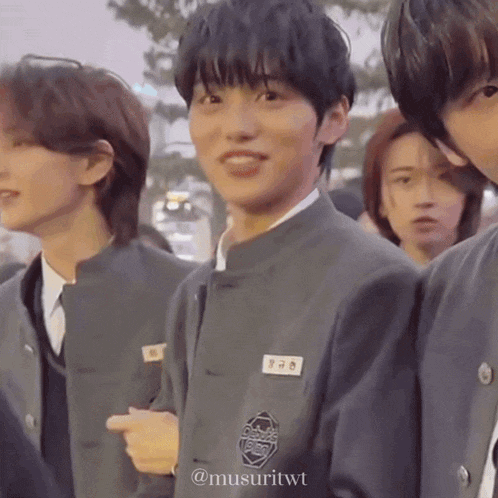 a group of young men are standing next to each other and one of them is wearing a name tag that says ' a '