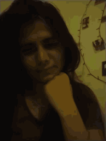 a woman laying on a bed with her hand on her face