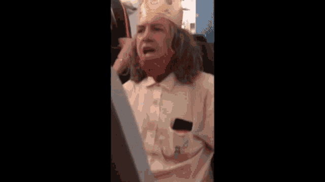 a man wearing a burger king crown and a red mask on an airplane .