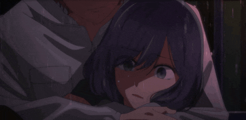 a person in a hooded sweatshirt is hugging another person in the rain