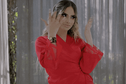 a woman in a red dress has a gold watch on her wrist