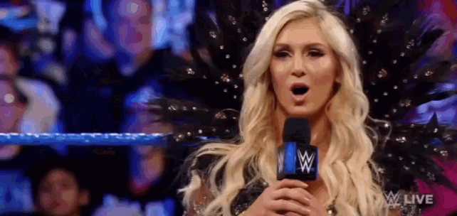 a woman is standing in front of a microphone with her mouth open .