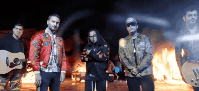 a group of men standing next to each other in front of a fire