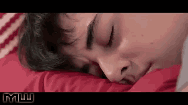 a close up of a person sleeping with a red blanket