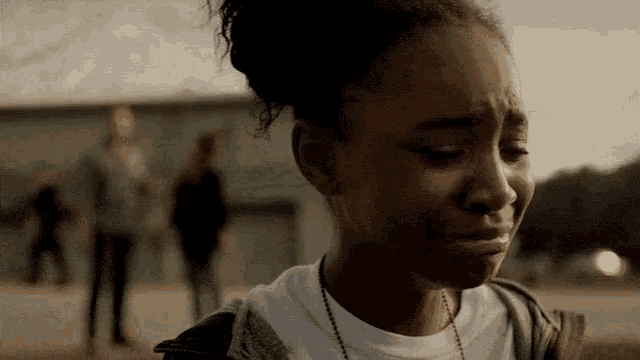 a young girl is crying in front of a building .