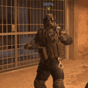 a man in a gas mask is standing in front of a fence with a percentage of 100 %