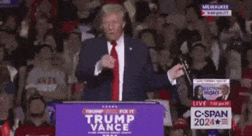 donald trump is giving a speech in front of a crowd at a podium .