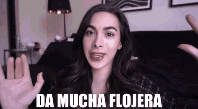a woman says " da mucha flojera " in front of a black couch