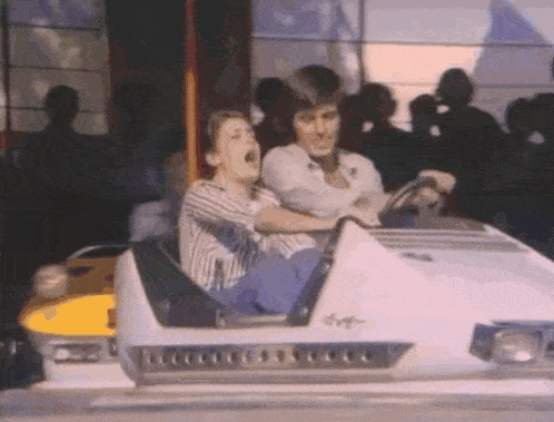 a man and a child are riding a bumper car
