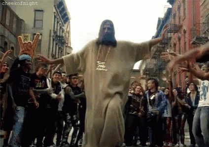 a man dressed as jesus is dancing in front of a crowd .