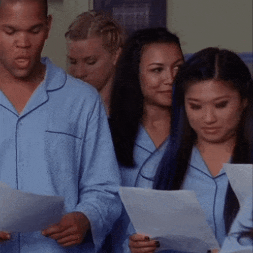 a group of people in pajamas are reading papers together