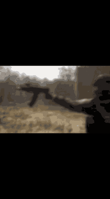 a blurry picture of a man holding a gun in a field .