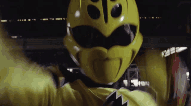 a close up of a yellow power ranger with a black star on the chest