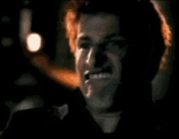a man with red hair is smiling in a dark room