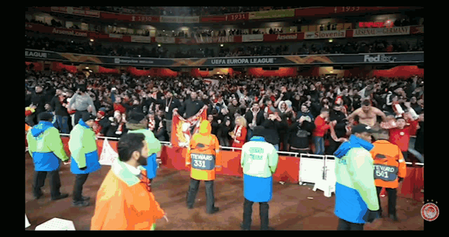 a crowd of people in a stadium with uefa europa league advertisements on the walls